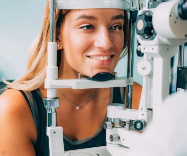 A woman getting an eye exam to check for 6 early signs of AMD.