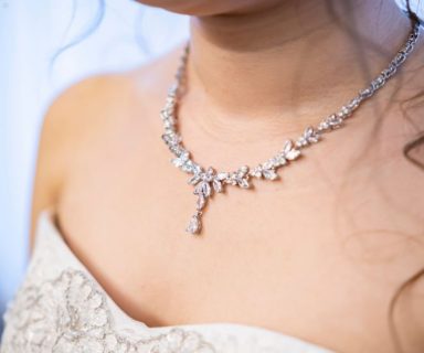 A close up of a diamond necklace on a bride.