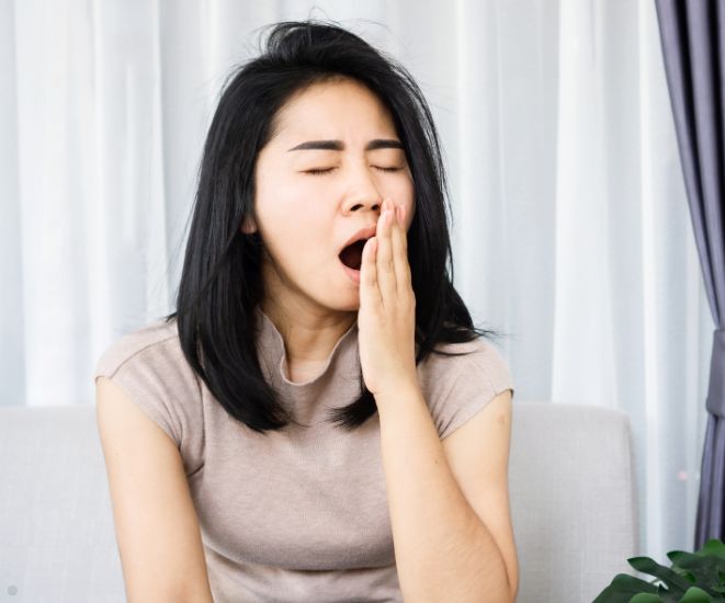 A woman yawning.