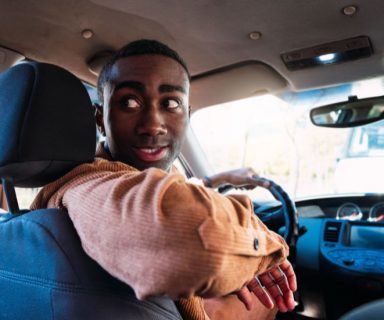 A man driving a used car.