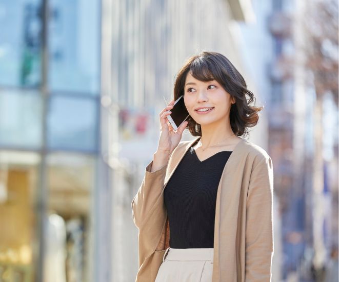 A woman talking on a cell phone while walking outside.